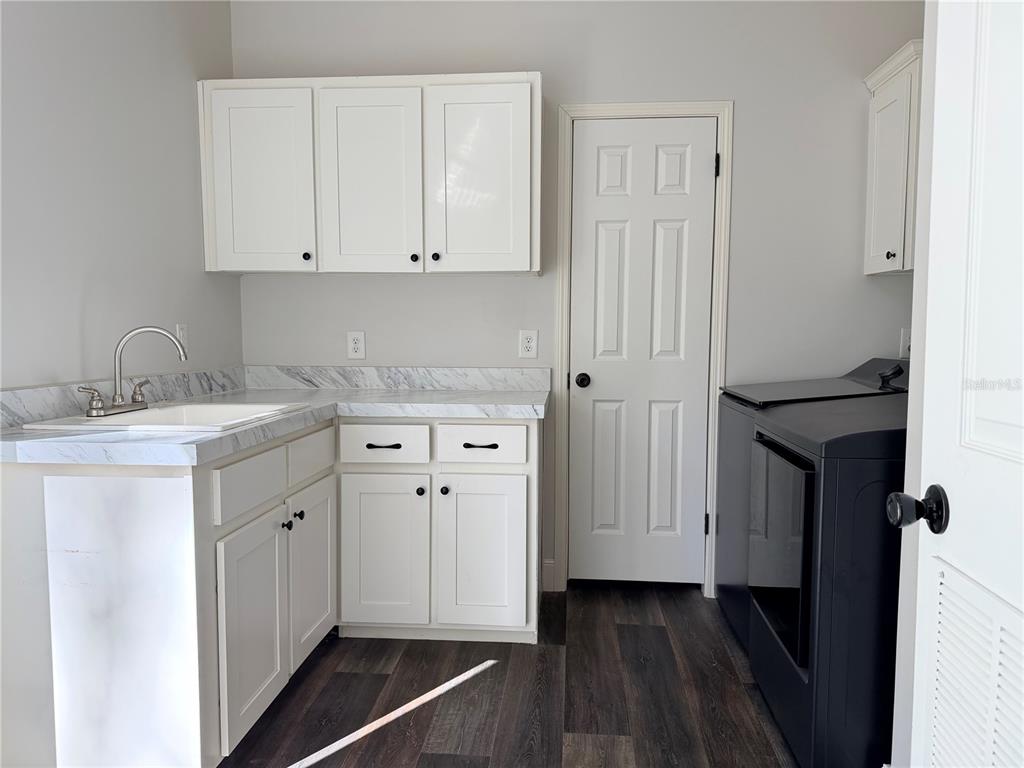 4440 Southwest 63rd Boulevard Gainesville, FL 32608 - Photo 43 of 49 a utility room with cabinets washer and dryer