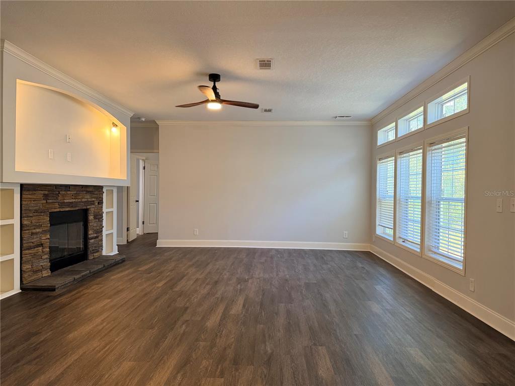 4440 Southwest 63rd Boulevard Gainesville, FL 32608 - Photo 9 of 49 a view of an empty room with wooden floor fireplace and a window