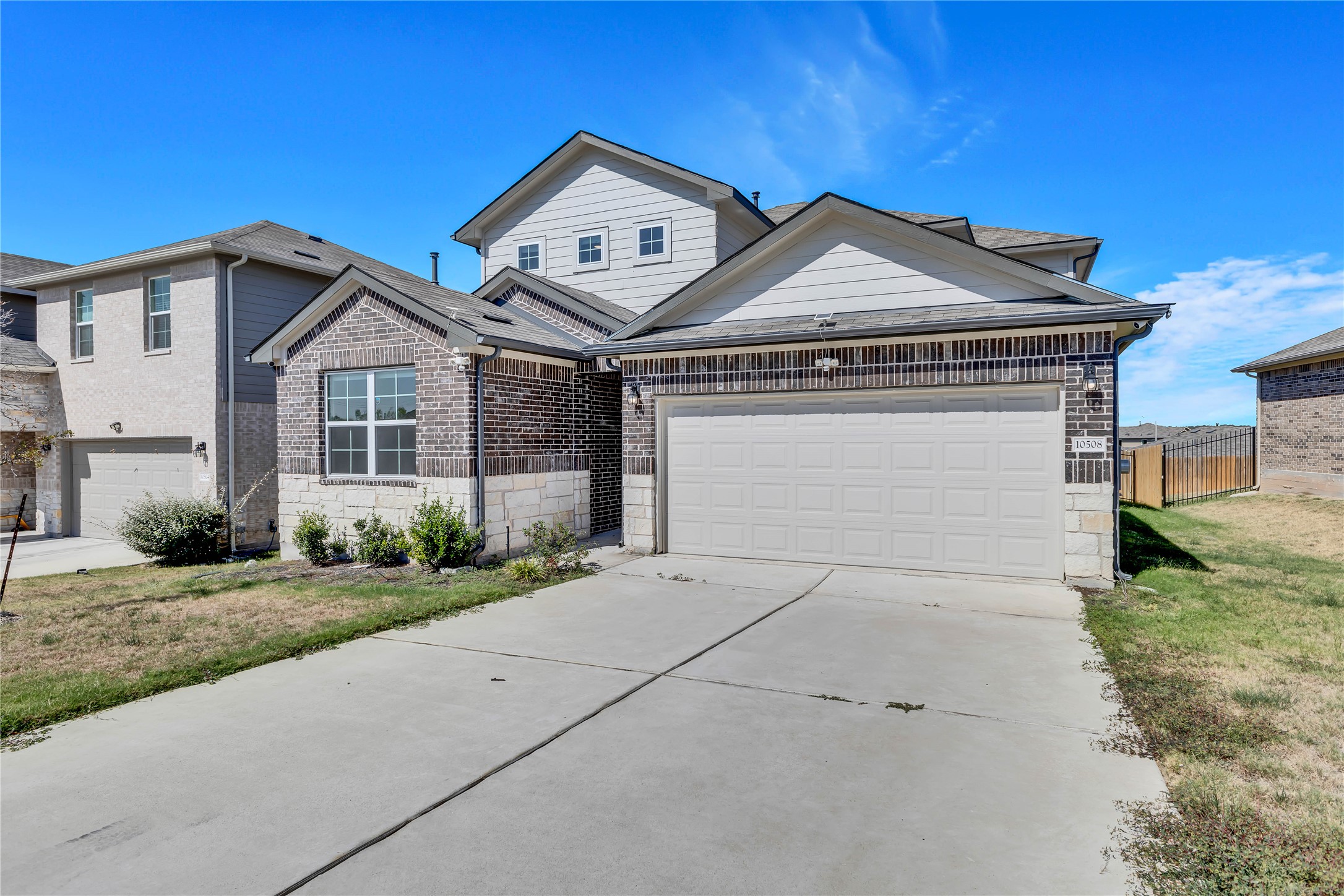 10508 Defender Trail Austin, TX 78754 - Photo 3 of 28 A striking modern facade blends brick and siding, featuring an attached garage and neatly landscaped entryway.