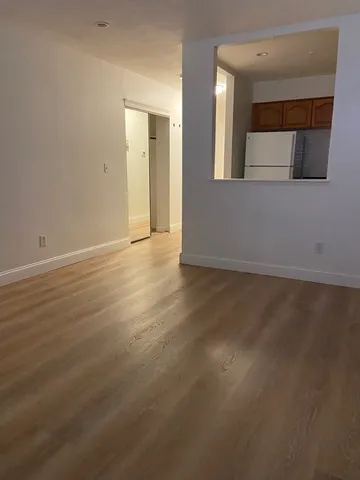 an empty room with wooden floor and mirror
