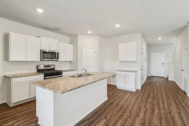 a kitchen with a sink stove and microwave