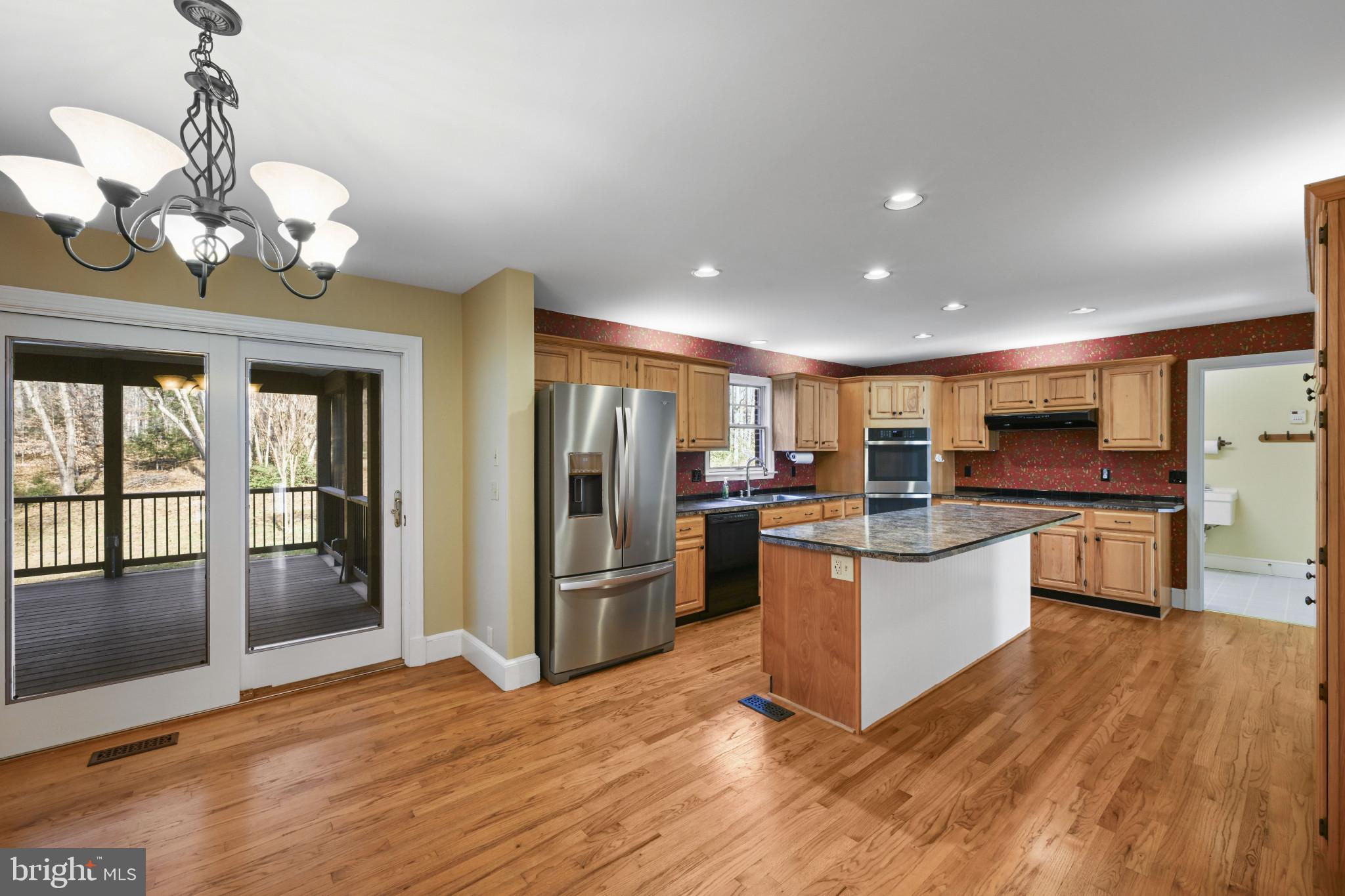 16966 Teagues Point Road Hughesville, MD 20637 - Photo 11 of 72 a kitchen with stainless steel appliances granite countertop a refrigerator and a stove top oven