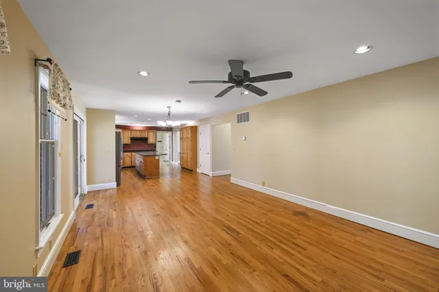 a living room with a black white checkered floor with a gaming machine and wooden floor