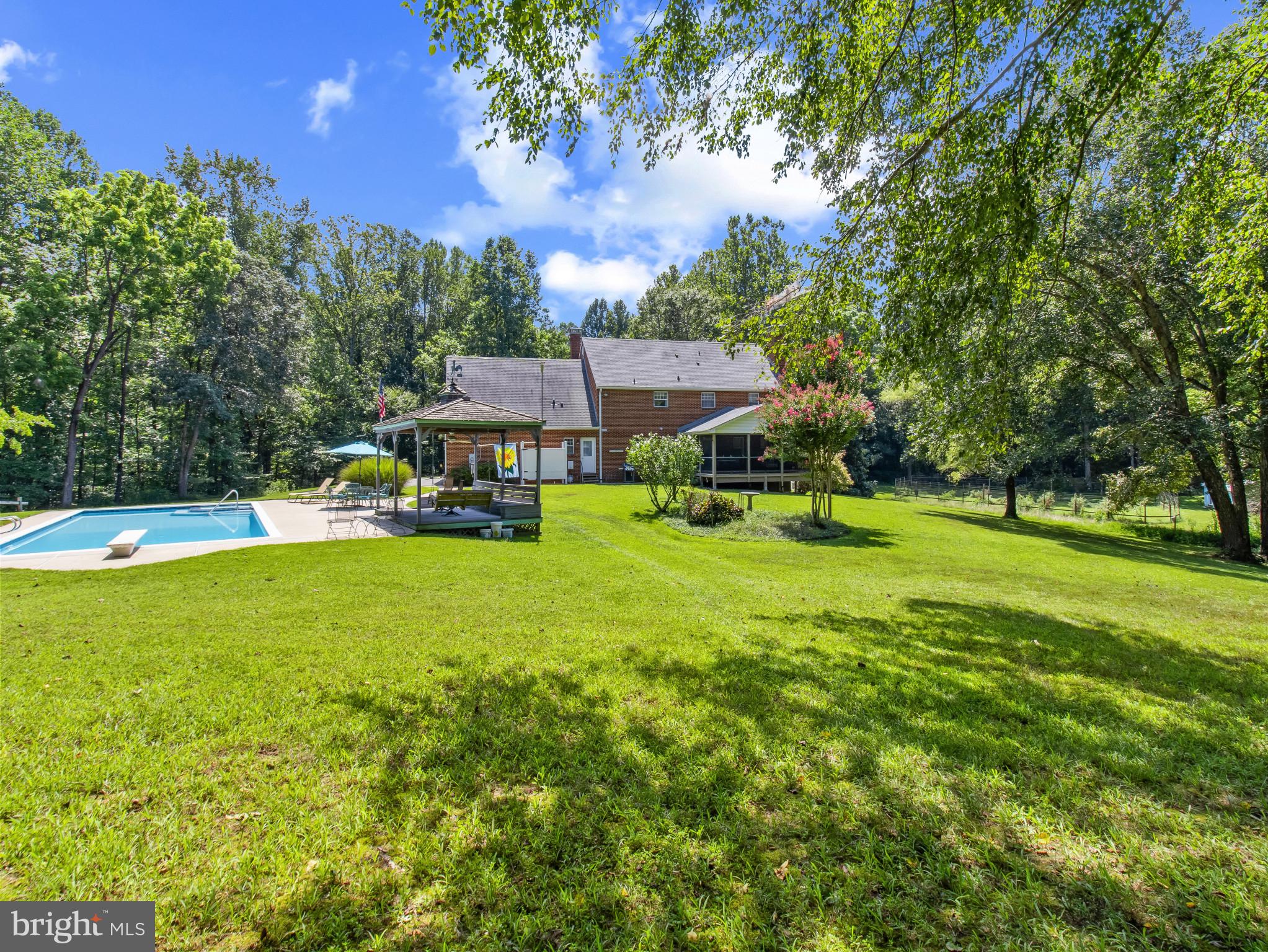 16966 Teagues Point Road Hughesville, MD 20637 - Photo 39 of 72 a view of an house with swimming pool garden and trees