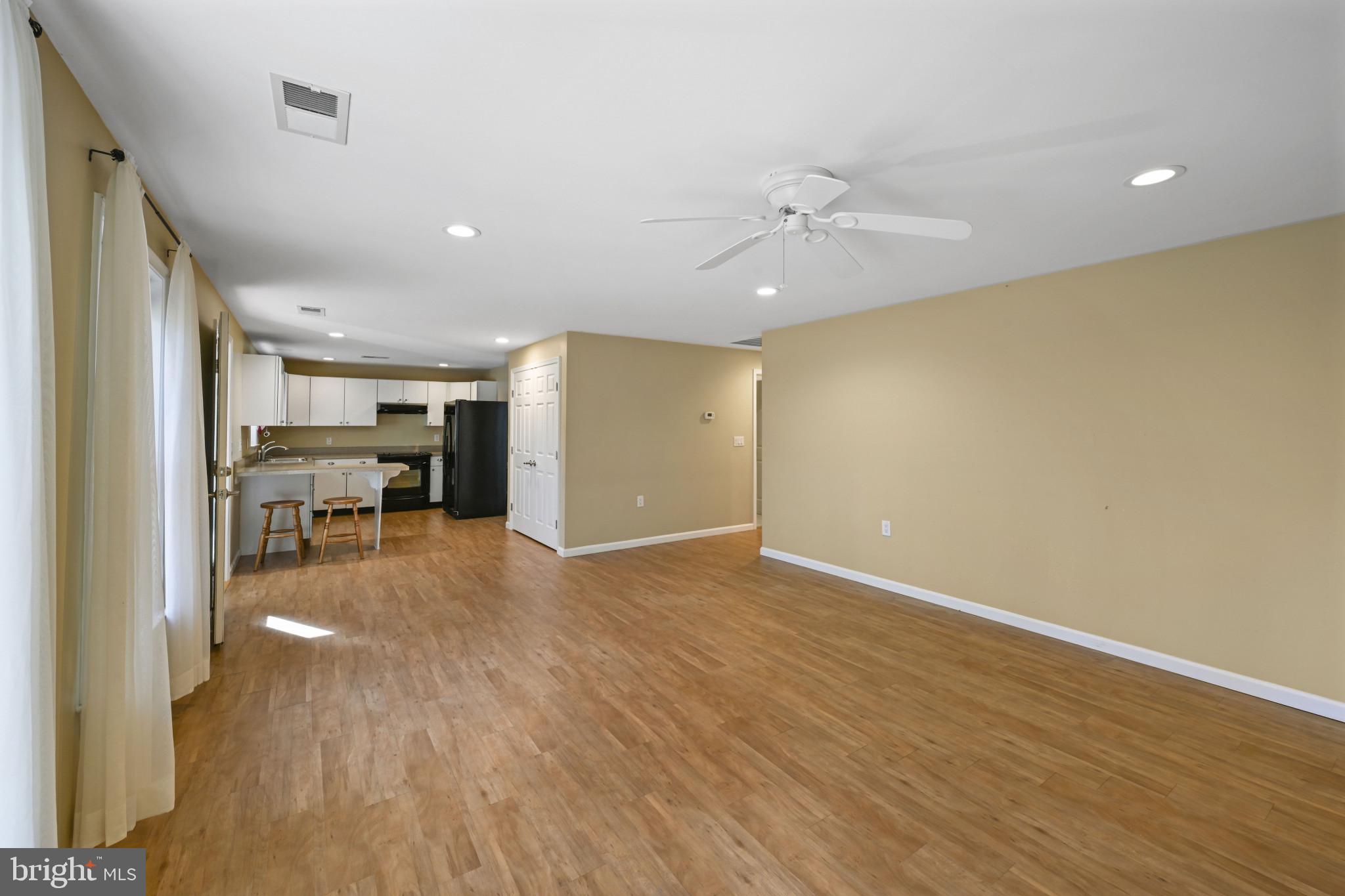 16966 Teagues Point Road Hughesville, MD 20637 - Photo 55 of 72 a view of a livingroom with furniture wooden floor a ceiling fan and windows