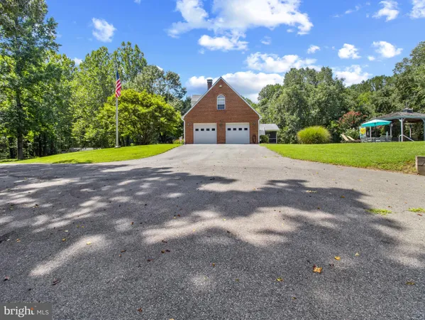 a view of a house with a yard and large tree