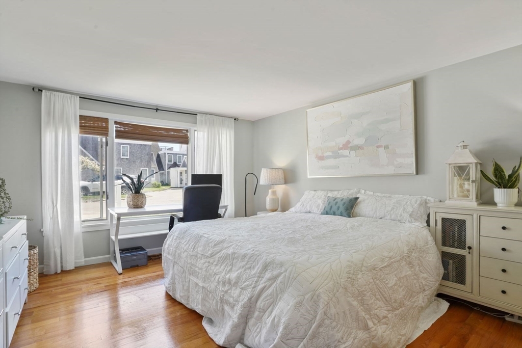 1 Commodore Court, Unit 104 Hull, MA 02045 - Photo 15 of 35 a bedroom with a large bed and a desk