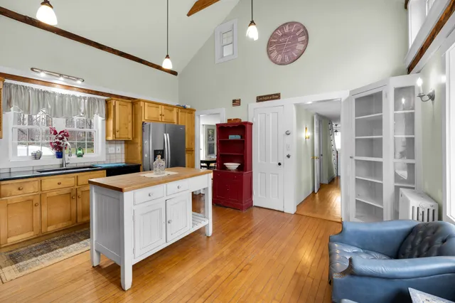 a kitchen with stainless steel appliances granite countertop a stove a sink dishwasher and white cabinets with wooden floor