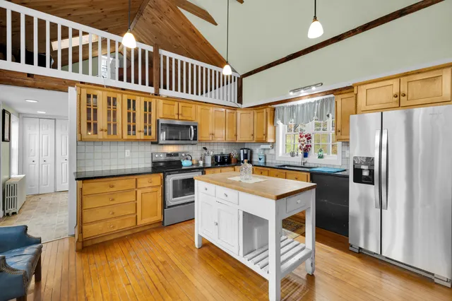 a kitchen with stainless steel appliances granite countertop a stove a refrigerator and a stove top oven