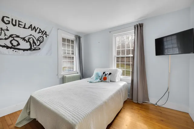 a bed sitting in a bedroom next to a window