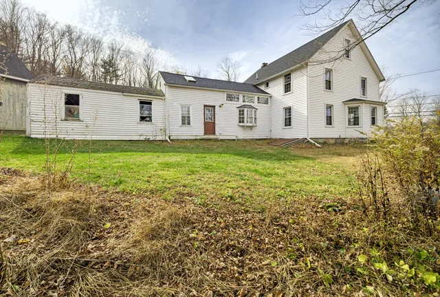 a view of a white house with a yard