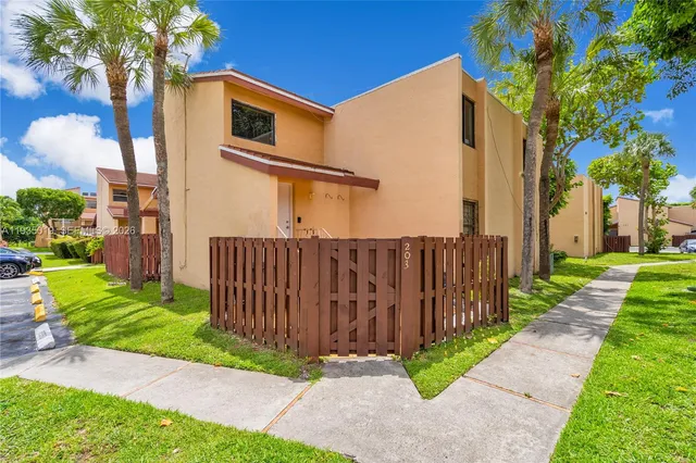a front view of a house with a yard and potted plants