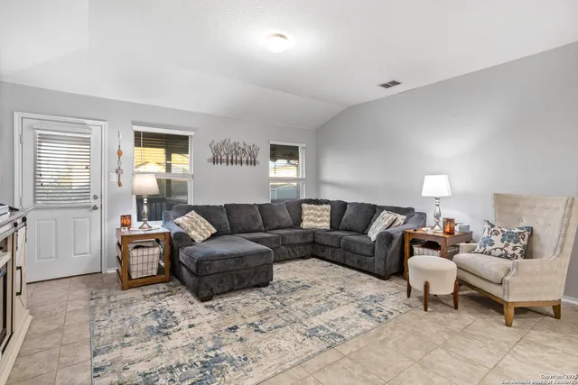 a living room with furniture a lamp and a window