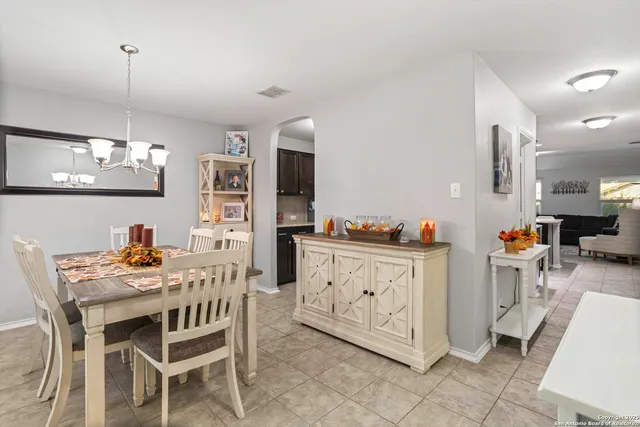 a kitchen with stainless steel appliances kitchen island granite countertop a table chairs sink and cabinets