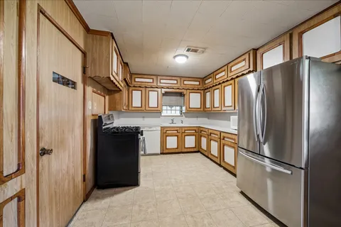 a kitchen with stainless steel appliances granite countertop a refrigerator and a stove top oven