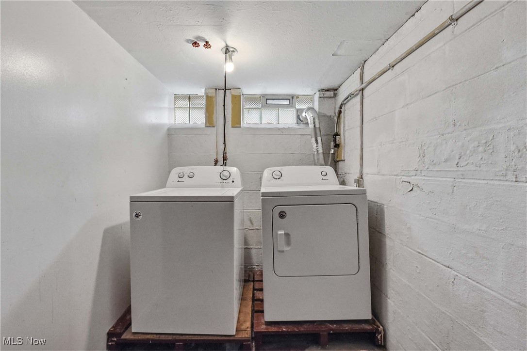 6506 Snow Road Parma, OH 44129 - Photo 23 of 25 Laundry room featuring washer and clothes dryer and a textured ceiling
