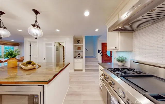a kitchen with stainless steel appliances granite countertop a stove and a white cabinets