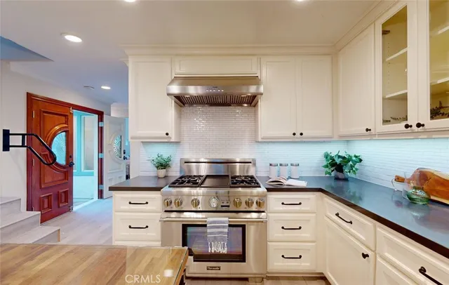 a large kitchen with stainless steel appliances granite countertop a refrigerator and a sink