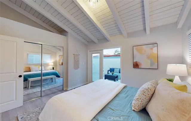 a bedroom with bed couch and wooden floor