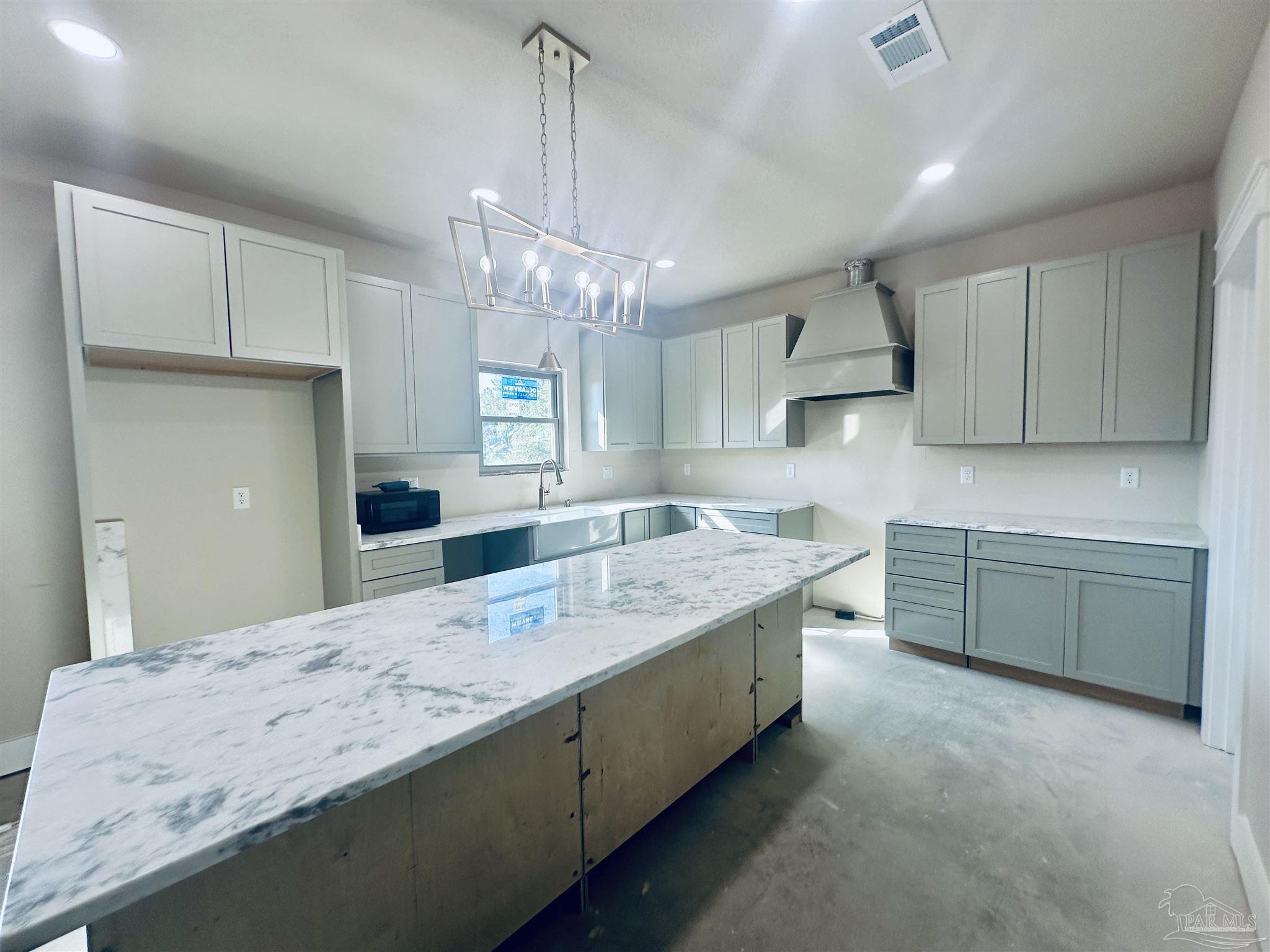 5009 Timber Ridge Drive Pace, FL 32571 - Photo 20 of 72 a large kitchen with kitchen island a sink stainless steel appliances and cabinets