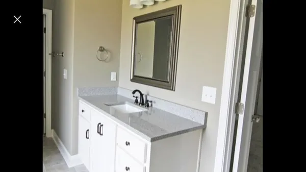 a bathroom with a granite countertop sink and a mirror