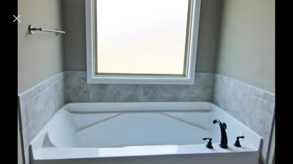 a bath tub sitting in a bathroom next to a window