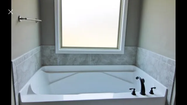a bath tub sitting in a bathroom next to a window