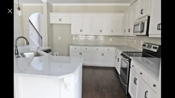 a kitchen with granite countertop a sink a stove and cabinets