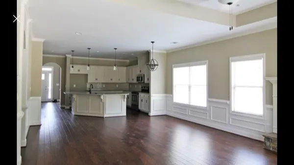 a large space with a large window and wooden floor