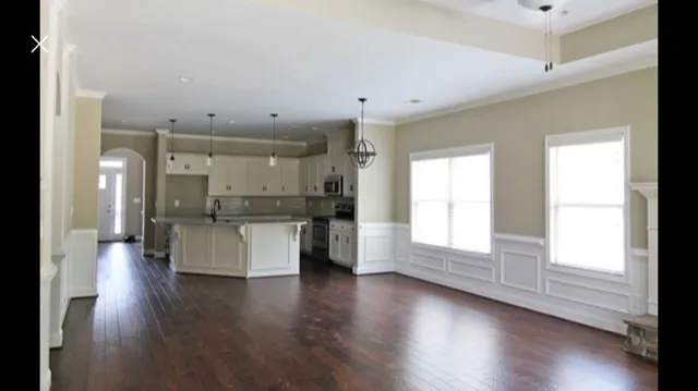 a large space with a large window and wooden floor