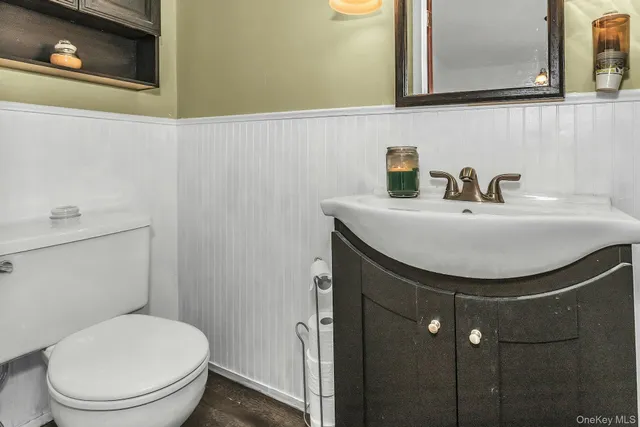 a bathroom with a sink a toilet and mirror