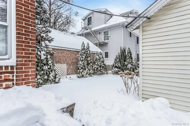 a view of a white house with a large tree