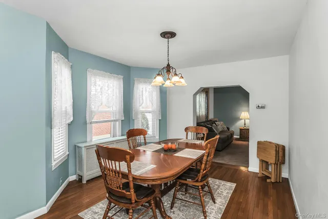 a dining room with furniture a chandelier and wooden floor