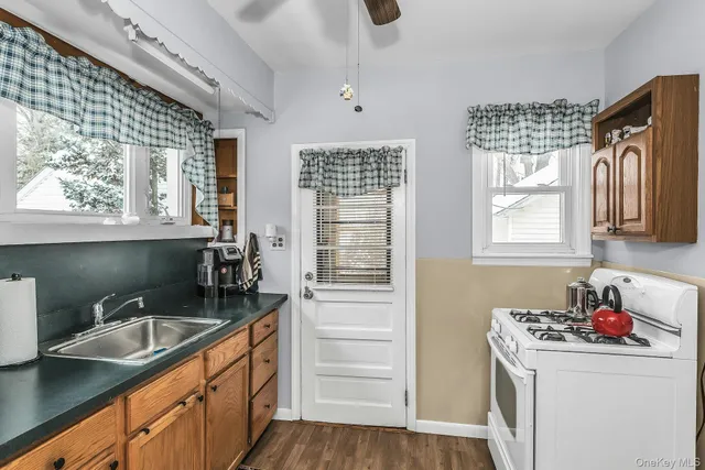 a kitchen that has a sink cabinets counter space and a window