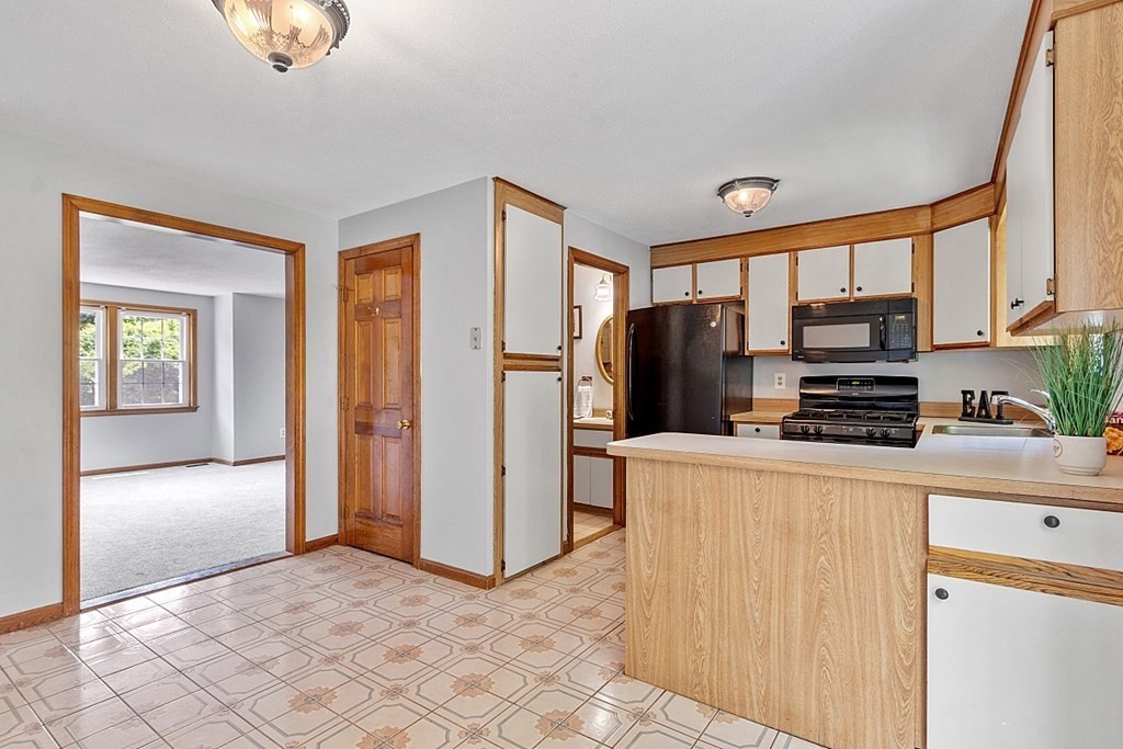 25 Juniper Place, Unit 9 Lowell, MA 01852 - Photo 12 of 42 a kitchen with stainless steel appliances granite countertop a refrigerator and a stove