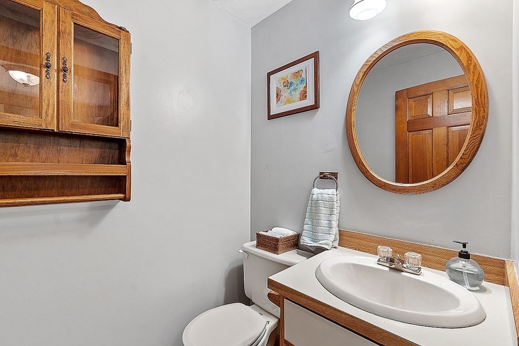 25 Juniper Place, Unit 9 Lowell, MA 01852 - Photo 13 of 42 a bathroom with a toilet sink and mirror