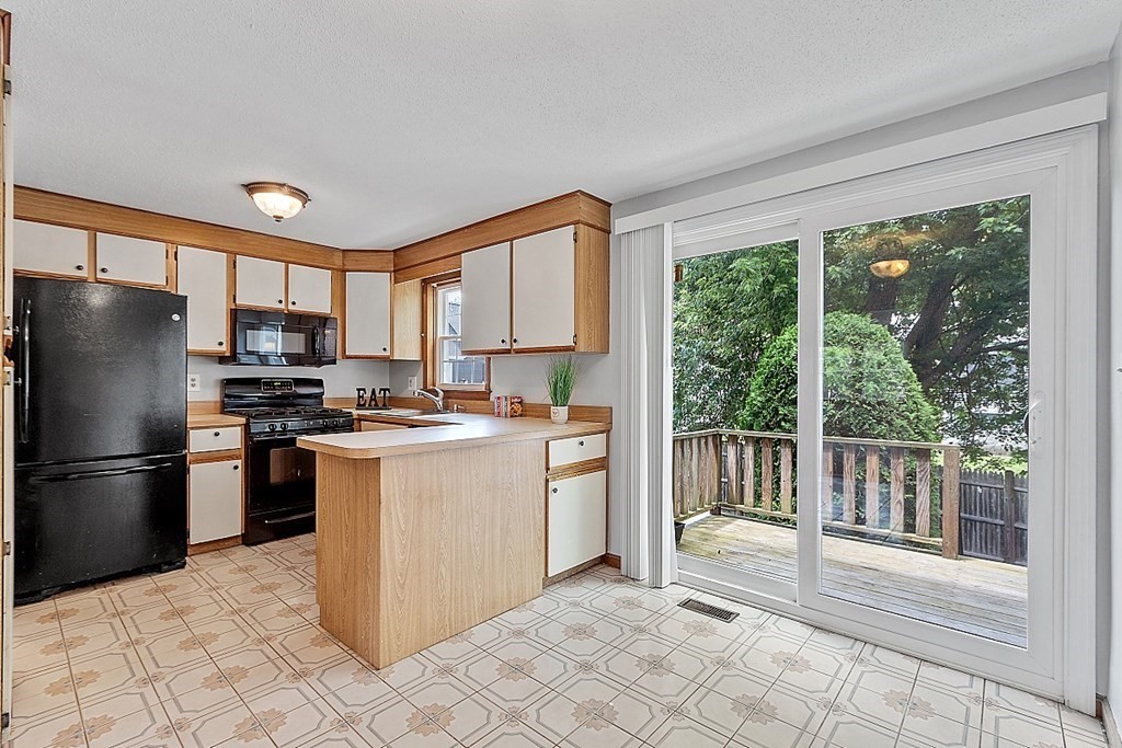 25 Juniper Place, Unit 9 Lowell, MA 01852 - Photo 2 of 42 a kitchen with stainless steel appliances granite countertop a refrigerator oven a sink and a large window