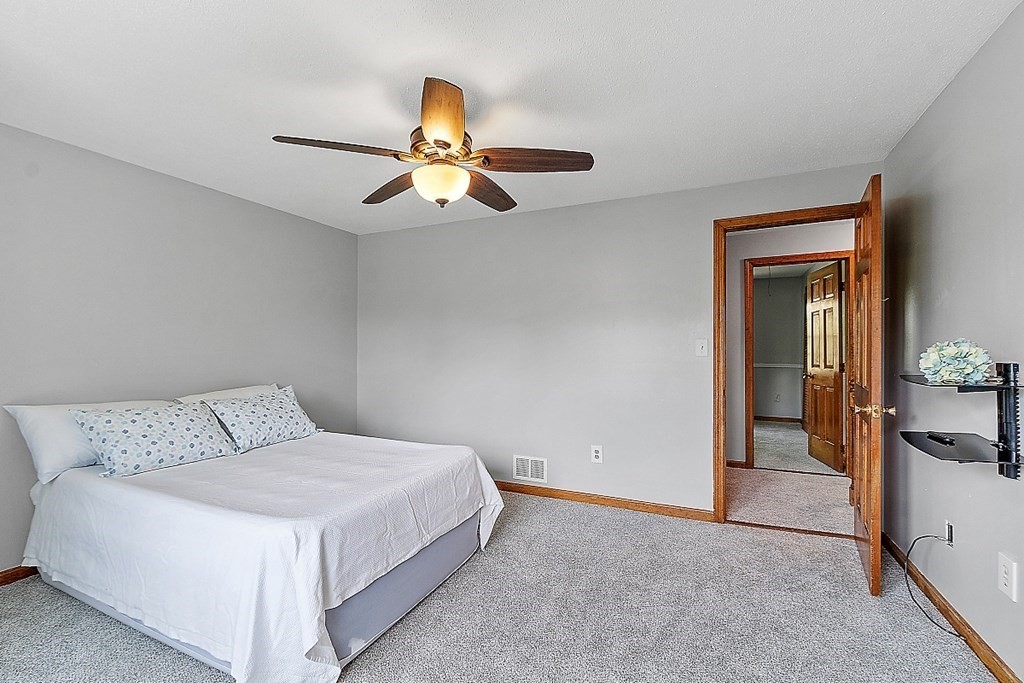 25 Juniper Place, Unit 9 Lowell, MA 01852 - Photo 22 of 42 a bedroom with a bed and a ceiling fan