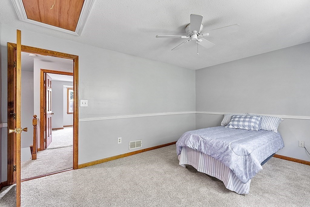 25 Juniper Place, Unit 9 Lowell, MA 01852 - Photo 24 of 42 a room with a bed and a ceiling fan