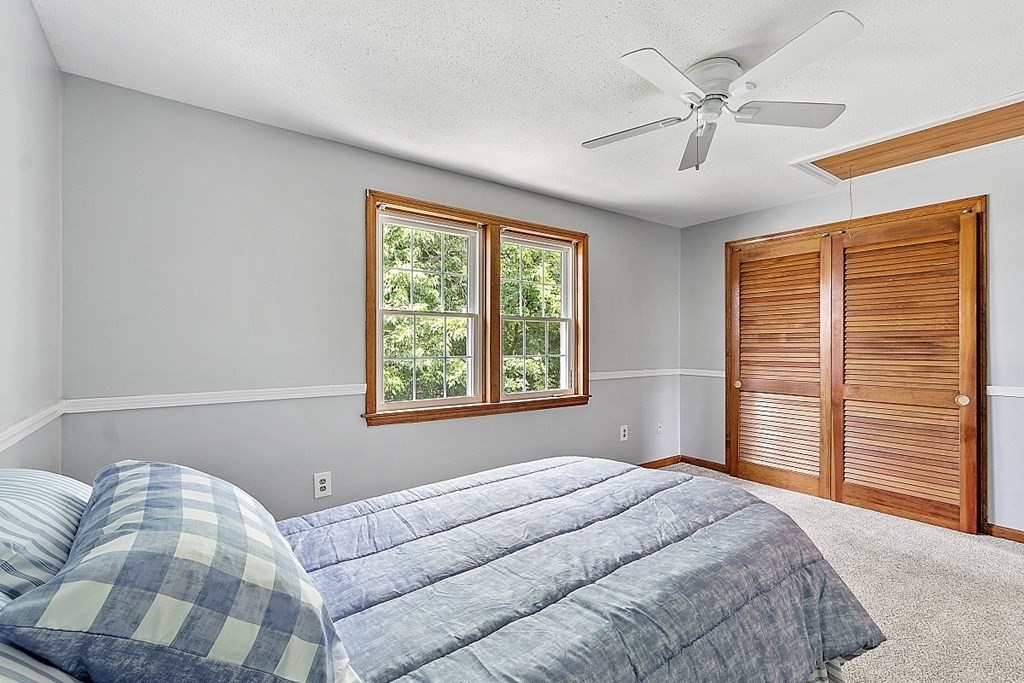 25 Juniper Place, Unit 9 Lowell, MA 01852 - Photo 25 of 42 a bedroom with a large bed and a chandelier