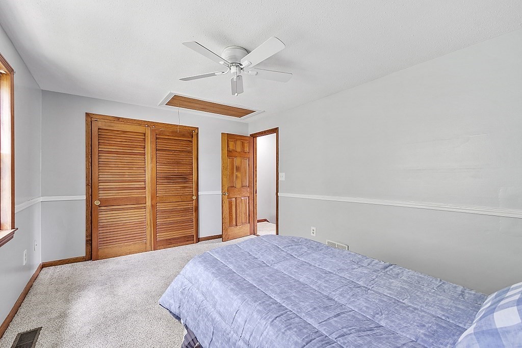 25 Juniper Place, Unit 9 Lowell, MA 01852 - Photo 26 of 42 a bedroom with a bed and a chandelier