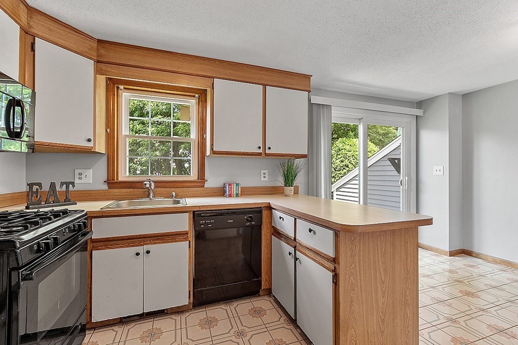 25 Juniper Place, Unit 9 Lowell, MA 01852 - Photo 6 of 42 a kitchen that has a sink and a stove