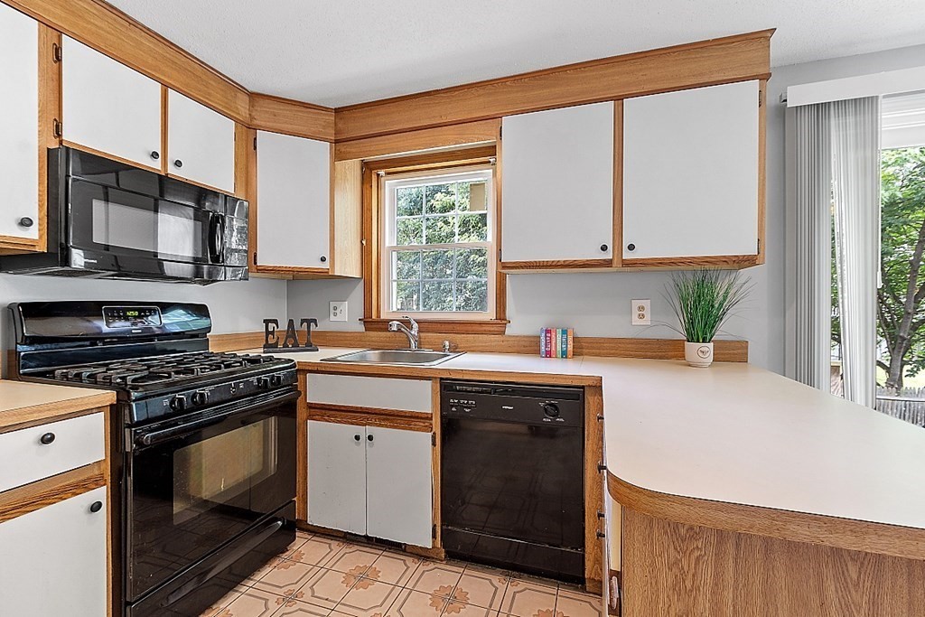 25 Juniper Place, Unit 9 Lowell, MA 01852 - Photo 7 of 42 a kitchen with a stove a sink and a microwave