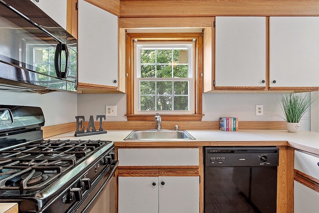 25 Juniper Place, Unit 9 Lowell, MA 01852 - Photo 8 of 42 a kitchen with a sink stove top oven and cabinets