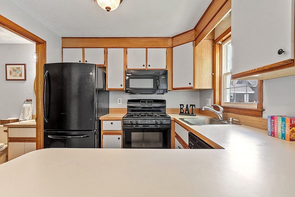 25 Juniper Place, Unit 9 Lowell, MA 01852 - Photo 9 of 42 a kitchen with a refrigerator a stove and a sink