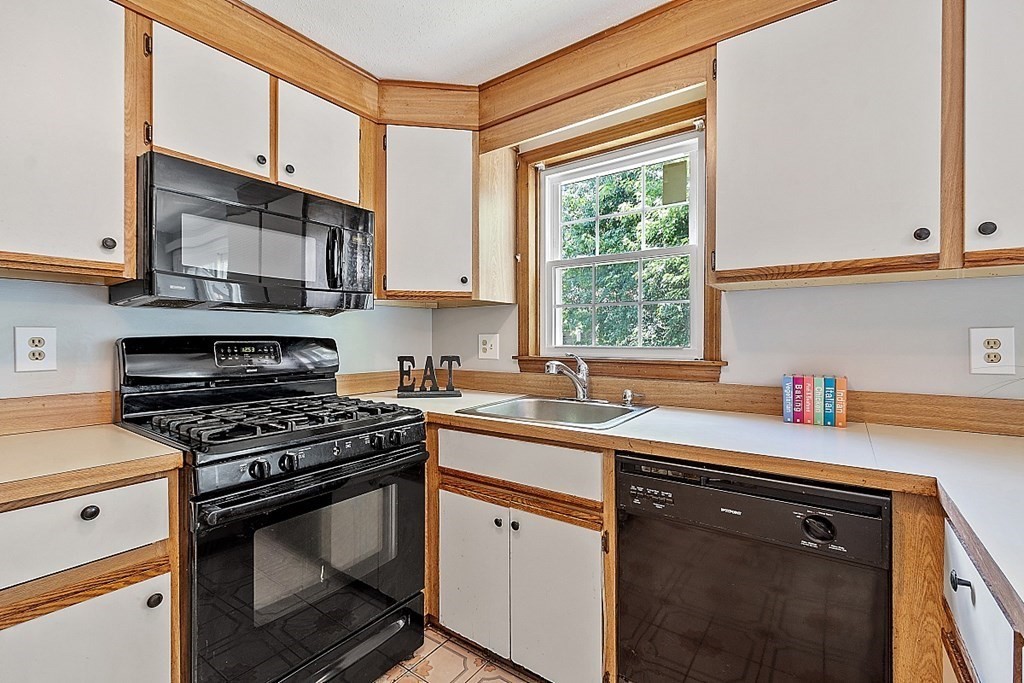 25 Juniper Place, Unit 9 Lowell, MA 01852 - Photo 10 of 42 a kitchen with stainless steel appliances a sink stove and cabinets