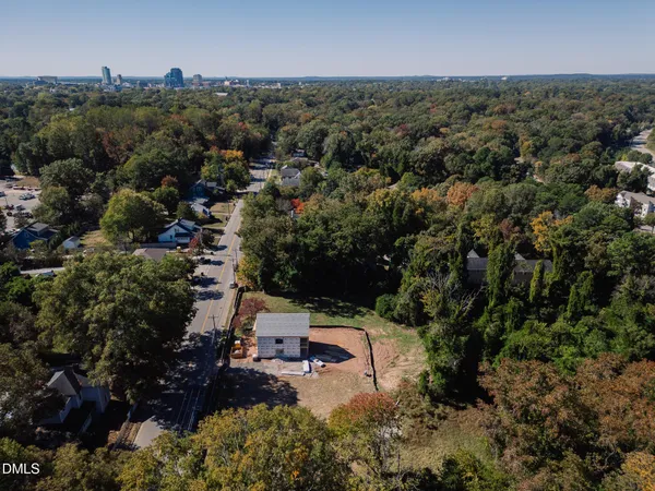 an aerial view of residential house with outdoor space and trees all around