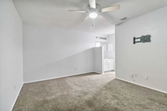 an empty room with a ceiling fan and a fan