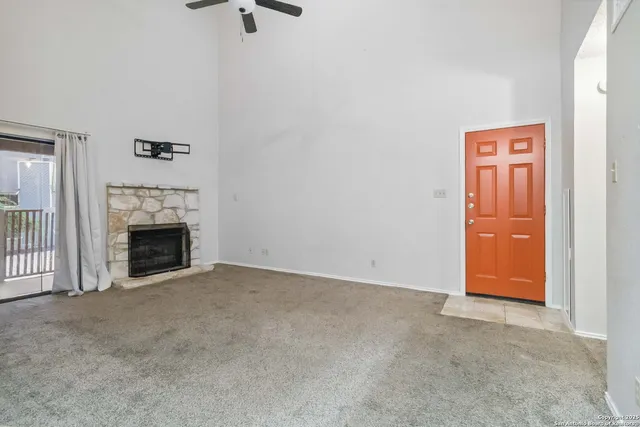 an empty room with windows and fireplace