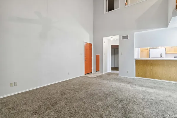 a view of an empty room with a kitchen